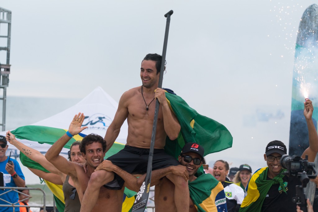 La camaradería del equipo brasileño se ha hecho notar durante toda la semana. El Medallista de Oro SUP Surfing Luis Diniz cargando al Medallista de Oro SUP Sprint Arthur Santacreu. Foto: ISA / Sean Evans 